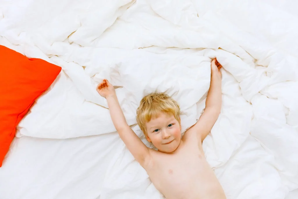 A child lying down on white sheets